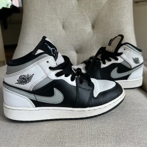 Jordan 1 mid White shadow  - Jordan 1 mid white shadow. Använt ett par gånger men fortfarande i  väldigt fint skick. Den andra bilden ser man lite slitage, annars är de i väldigt bra skick. Jag köpte mina för 3250kr från sold out. De passar även 38or💗box tillkommer ofc.66kr i frakt. 