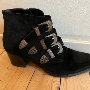 Ankleboots i mocka - Jättefina ankleboots i mocka med snygga spännen från Roots. Bra skick!