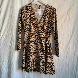 Klänning med tigermönster i stretchigt tyg från H&M. Aldrig använd men prislappen kvar! 