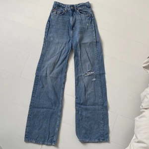 jeans med slitning - jeans i storlek 34 från H&M. jeansen har hög midja och slitning på vänstra knät. 