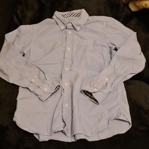 Skjorta ljusblå stl 146 - Skjortan är ljusblå i fint skick använd 2gånger Holly & Whyte Lindex märke