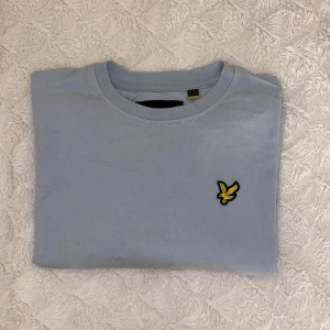 Croppad Lyle & Scott t-shirt  - Säljer denna t-shirt då den ej kommer till användning längre. Storlek S men passar XS också. Den är croppad alltså lite kortare i modellen och i en ljusblå fin färg:)