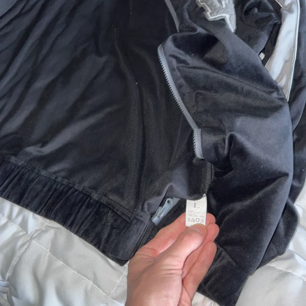 En svart tröja med mörkgråa detaljer och grått tryck i tyg som står LA. Är något mjukare material som är riktigt skönt. Storlek L . Hoodies.