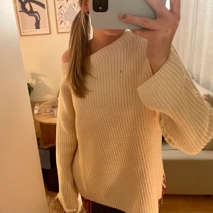 Stickad tröja  - En stickad tröja som går ner över axeln. Den är ljusbeige och lite ”grov” stickad! Den har även en liten slits vid sidan som man ej ser på bilderna. Det är spegeln som är smutsig inte tröjan!