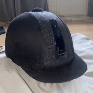 Svart ridhjälm  - Säljer min svarta ridhjälm som ej kommer till användning då jag slutat rida för lite mer än ett år sedan. Jag har använt den kanske 5 gånger max och har ej ramlat av med den så den fyller fortfarande sin funktion!! 