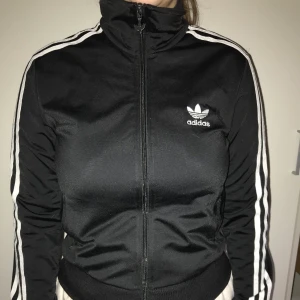 Adidas jacka - Svart adidasjacka med turtle neck / polokrage i storlek 38/M, passar även S. Lite smått nopprig. Om du köper någonting i min shop för över 50kr så får du något för 20kr på köpet (det finns en hel del att välja bland).