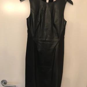 Skinnklänning - Oanvänd skinnklänning från H&M stl 34. Så himla fin men lite för liten för mej. Fodrad, längd strax ovanför knät. Frakt betalas av köparen.