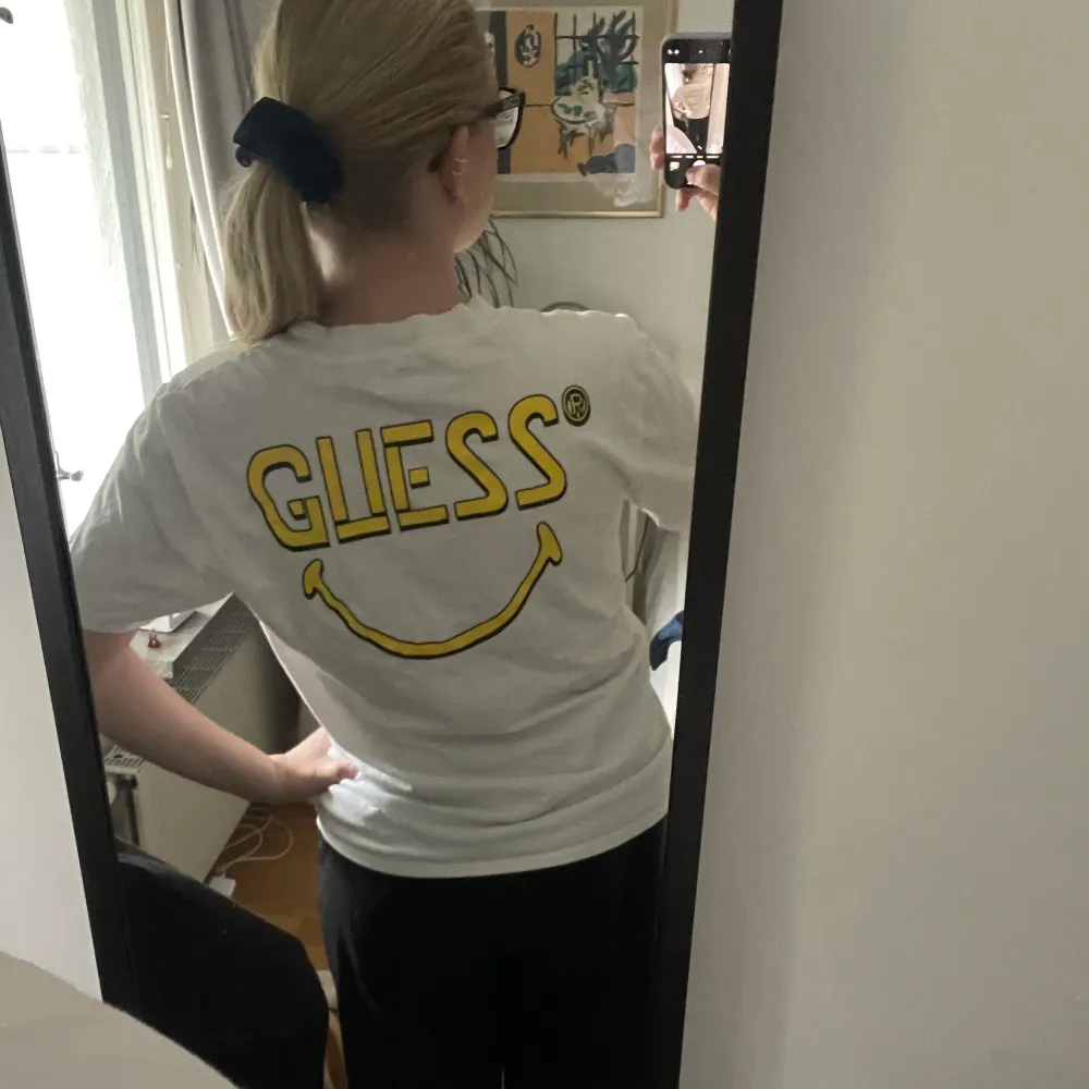 Snygg t-shirt med gult tryck från märket Guess köpt på själva Guess butiken i New York. Använd ett mycket fåtal gånger, därav i princip i nyskick. Passar även en M eller L pga oversized passform! . T-shirts.