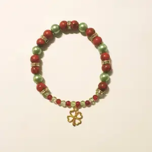 Röd/grön armband med en guldig 