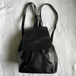 En svart Prada eller ”Prada” -väska. 🕷