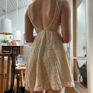 Varm-vit spets-klänning med öppen rygg. Använd en gång, mycket fint skick. 