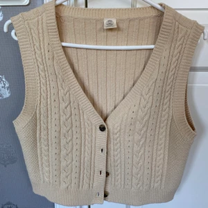 Stickad väst  - Beige stickad väst från Urban Outfitters, storlek L men skulle säga att den passar mer som S