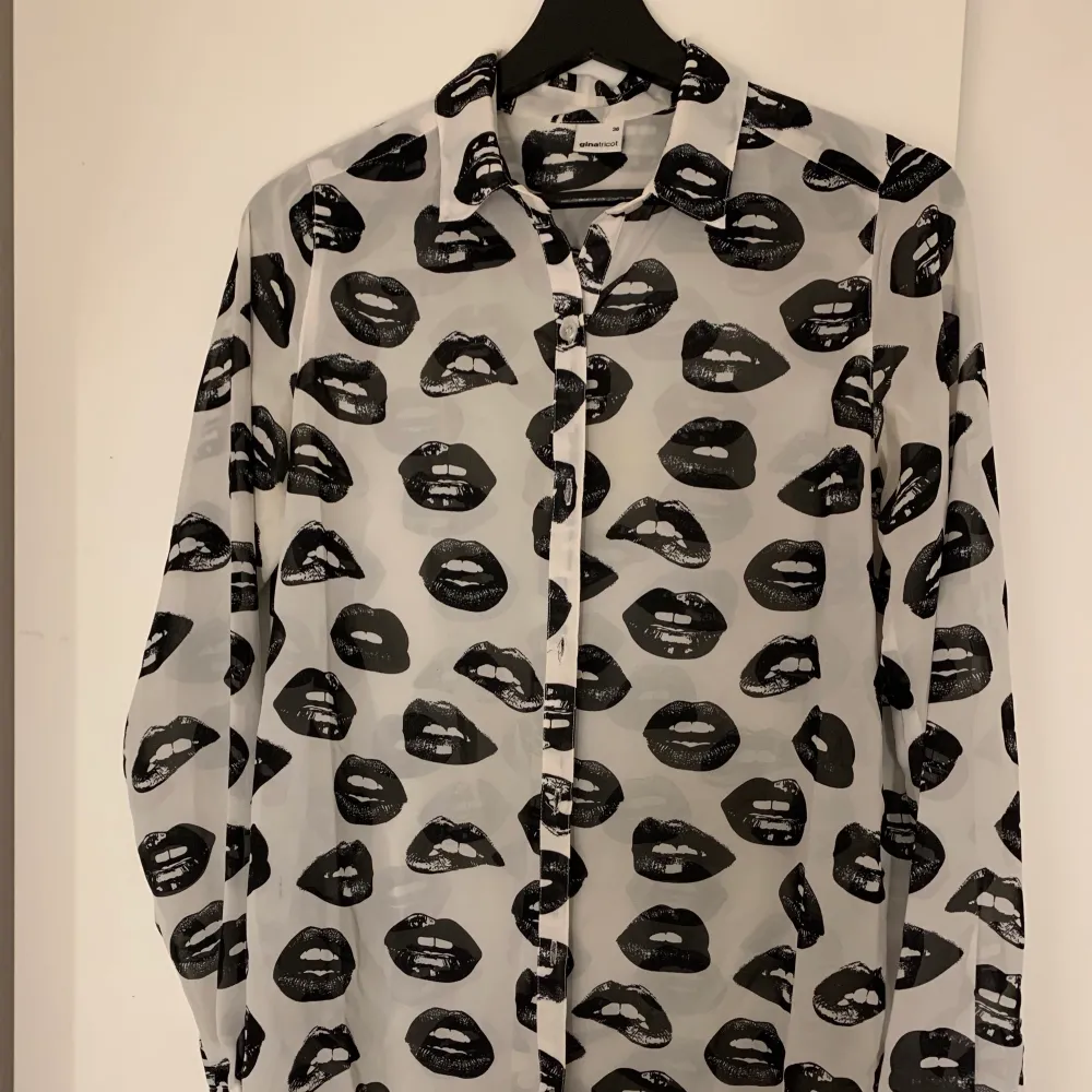 Skjorta ifrån Gina tricot men mun/läpp print på i svart och vitt mönster. Storlek 36. Använd några gånger men fint skick. Skjortor.