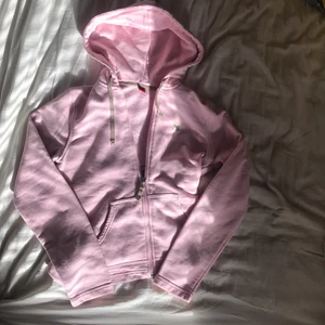 zip up  - En ljus rosa zip up med en grön fjäril på vänstra bröst. Inga fläckar och helt nopper fri. 