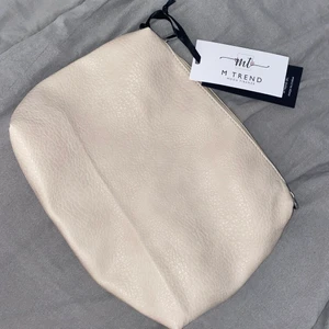 Necessär  - En beige necessär ifrån ett uf-företag. 