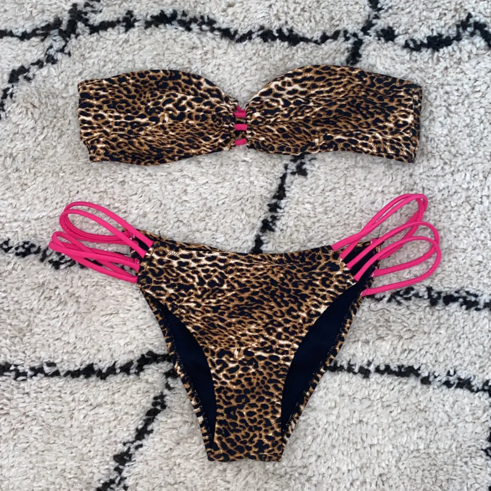 Lejopardmönstrad bikini med rosa detaljer från Nelly beach. Överdelen är i storlek M och nederdelen är i storlek L.. Övrigt.