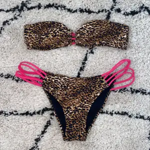 Lejopardmönstrad bikini med rosa detaljer från Nelly beach. Överdelen är i storlek M och nederdelen är i storlek L.