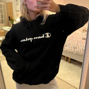 Champion vintage Hoodie - Säljer denna hoodien från Champion. Svart med vitt tryck. Stl XXL, men sitter oversized som en L på mig som brukar ha S. Bra skick!!