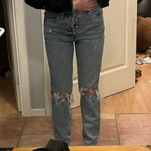 Mom-Jeans - Jeans med hål i från H&M köpte förra året. Det är knappar och inte en dragkedja:) mom jeans smalare i midjan. fint skick skriv vid frågor och intresse💗