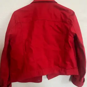 En röd och fin jeansjacka i en kortare modell, jackan är i ett bra skick. Inköpt på hm och är i storleken S