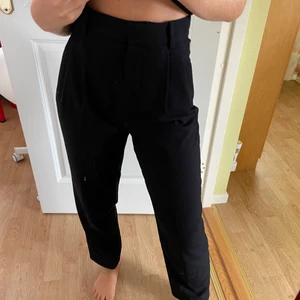 Svarta kostymbyxor från H&M - Svarta kostymbyxor från H&M i mom-modell. Ankellängd på mig som är ca 162 cm lång. Köparen står för eventuell frakt!