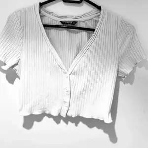 En söt, kort t-shirt med knapar från SHEIN. Den har inga fläckar eller hål. Storlek XS men passar även S. 50kr + frakt.❤️