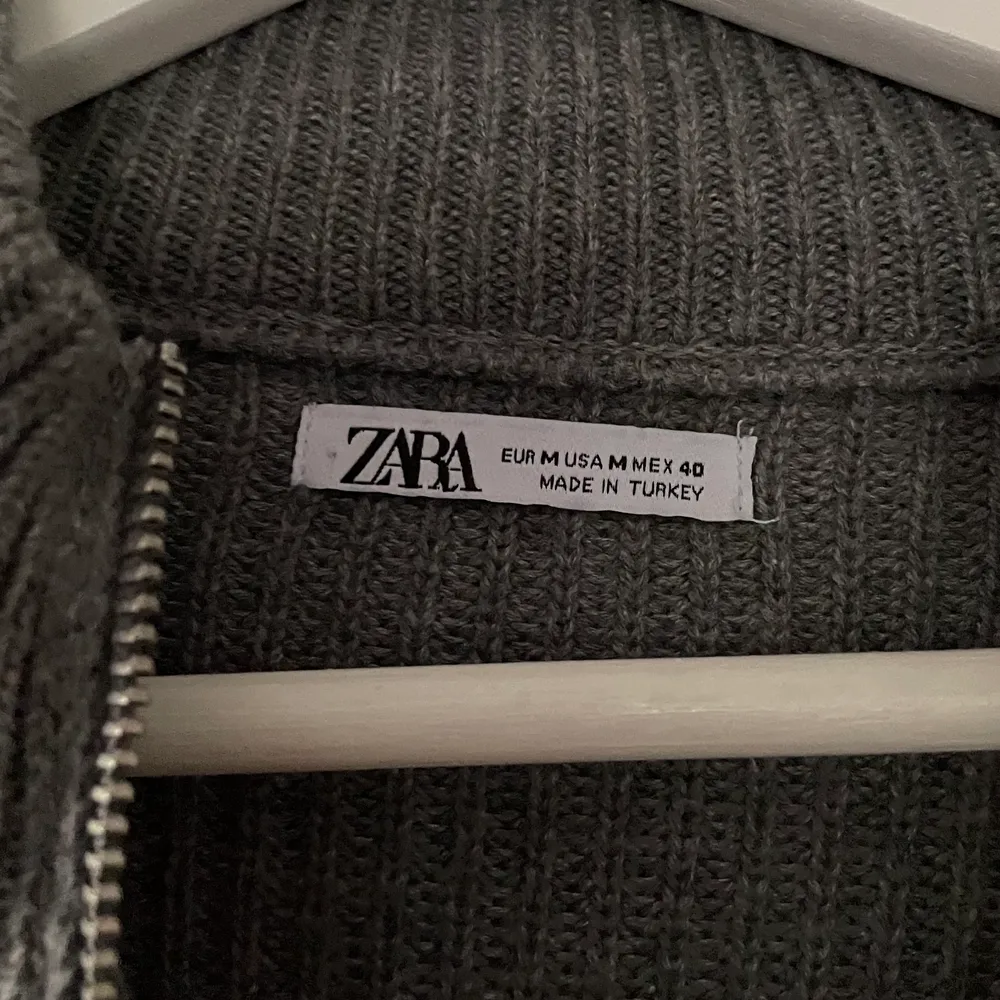 En grå stickad zip hoodie från Zara i storlek M. Varav är i bra skick och har inga tydliga defekter. Skriv vid funderingar! Nypris ~500. Stickat.