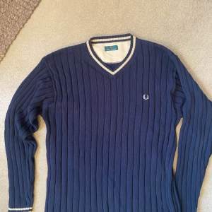 En skön retro knitted sweater från Fred Perry. Är i stil med en tenniströja och är i grymt skick!
