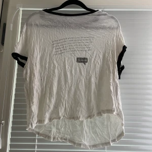 Lös t-shirt med text i storlek L - Välanvänd tröja med text på. Är ganska kort för mig med stor byst och sitter väldigt löst. Stretchigt material. Har inget strykjärn så därför är den väldigt skrynklig.  Jag har katt och kanin!
