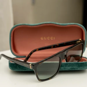 Gucci solglasögon  - Solglasögon från Gucci, fint skick. Finns dock en repa på ena glaset som inte syns vid användning eller påverkar. Vet inte om en optiker kan få bort den. Nypris va ca3500kr. Följer med fodral samt putsduk  