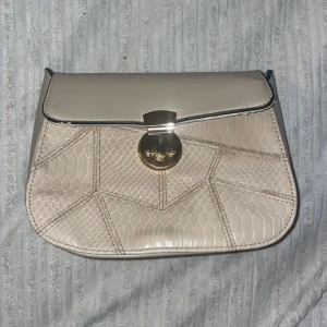 en beige märkesväska! - En jättefin märkesväska från SIVIAN HEACH som är ett italienskt märke, super fin väska får palts med mycket i, använt en två gånger inte mer än så, köptes för 2.500 kr i italien , pris går och diskuteras.