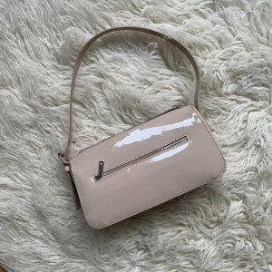 H&M baguetteväska (beige/ljusrosa) - Baguetteväska i lack, oanvänd. 