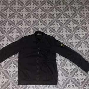 Stone Island Overshirt - Condition: 9/10 Features  - Black  - Chest pocket  - Buttons on cuffs  - Two-way front zip closure  - Flexible collar
