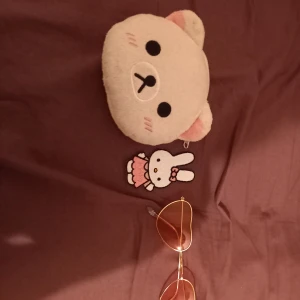 Plånbok kurulillakuma, hjärtformade solglasögon och tyg märke  - Fina saker sällan använda. (Tyg märke 10 kr såld)  , solglasögonen 25kr och plånbok 50kr. 