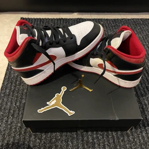 Jordan 1 Mid Gym Red Black White - Säljer mina jättefina jordans i storlek 36 då de är för små. Lådan och klistermärket skickas med skorna☺️ Vill du ha fler bilder så e de bara att skriva så löser jag de. Köpta för 2099kr och säljer för 1000kr + frakt. Priset kan diskuteras!