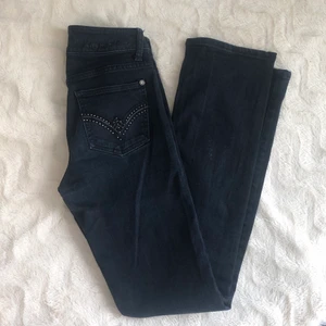 Lågmidjade jeans - Äldre lågmidjade jeans från GinaTricot. Gulliga bakfickor med pärlor! W24 L32. Bra skick utan hål elr slitningar men den svarta färgen är mer urtvättad som syns på bilder. Tightare över låren men sedan raka/lite lösare nedanför knäna. Säljes pga för små💓