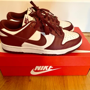 Nike Dunk Low - Nike Dunk Low i vinrött och vitt. Mycket bra skick, använda få gånger då de var lite för små för mig. 