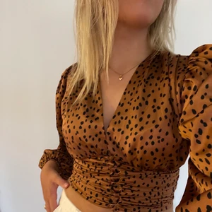 Blus/topp - Fin bronsfärgad topp med svarta prickar. Kommer från gina och är i storlek 38, jättefin men används tyvärr inte av mig. Hör av dig vid intresse, pris samt frakt kan diskuteras. Köpt är köpt. Hör av dig vid frågor😊