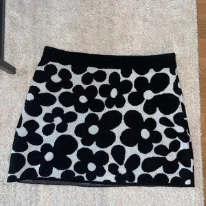 Stickad kjol - Stickad kjol med blommor. Aldrig använd. Prislapp kvar. 