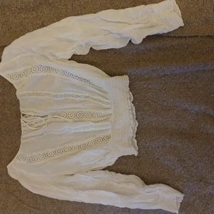 Vit croppad sommar-topp  - Fin sommar-topp från H&M, funkar bra för xs-s beroende på hur pösig man vill ha den. Jättefina spetsdetaljer och snörning. Frakt tillkommer!