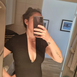 Svart v-ringad body från bikbok stl M - Säljer svart stringbody från bikbok. Inköpt för drygt 5 år sedan. Mkt sparsamt använd. Säljer pga tight över bysten. Har en djup v-ringning fram. I mkt gott skick. Köpare betalar frakt.