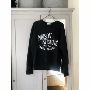 Svart sweatshirt från Maison Kitsune. Finns ett litet hål på baksidan som inte syns (obs! Är lagat) 