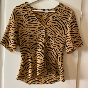 En tiger mönstrad topp från H&M - Köpte denna tiger tröja med en större v-ring och mest därför den inte kommit till användning då v-ringen varit för stor för mig personligen. 
