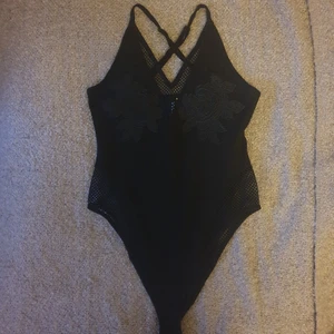 Body i mesh och spets  - Jättefin body i mesh med nätdetaljer och broderade rosor. Strlk S. Sparsamt använd och i gott skick! Frakt tillkommer. 