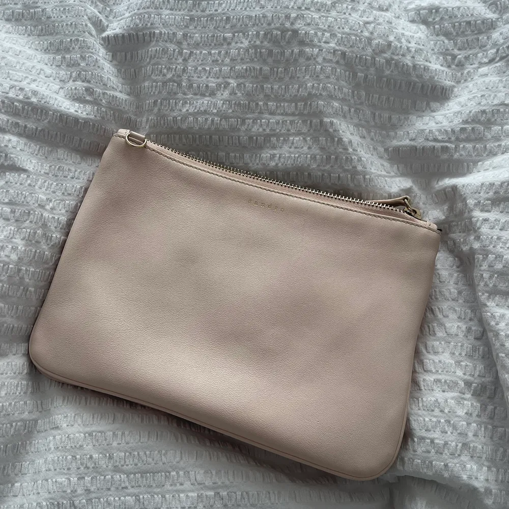 Fin Sandro väska i ljusrosa nästan beige färg, crossbody med guldfärgad länk, avtagbar så kan även användas som clutch. Tvådelad, se sista lånade bilden, fint skick. Mått 17x25cm, skriv för fler bilder.. Väskor.