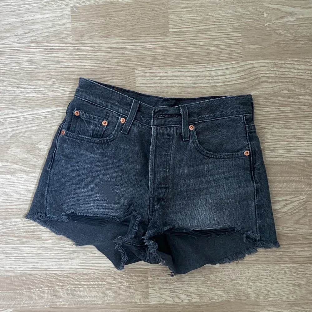 Ett par grå/svarta jeans shorts med märket levis i storlek W24.. Shorts.