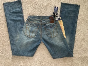 Lågmidjade bootcut jeans - Miss Sixty jeans stl 24 men passar även 25, jeansen har innerbensmåttet 86,6 cm och midjemått tvärs över 32,5 cm. Jeansen är köpta second hand men aldrig använda, prislappen kvar