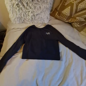 Tränings tröja långärmad - Jag säljer en svart långärmad träningströja i storlek S. Den rä ribbad och har ett stretchigt material.sälher då jag inte fått användning av den.
