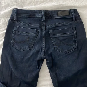 LTB jeans  - Lågmidjade bootcut jeans från LTB i storlek W25 L32. Svarta men kan se mörkblåa i vissa ljus. Använda men inte slitna. Säljer då de är förstora! 