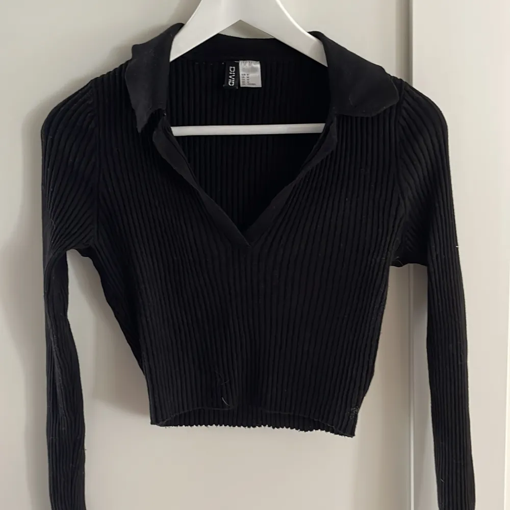 En kort långärmad svart tröja från H&M. . Stickat.